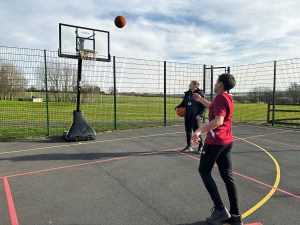 High School pupil doing basketball shooting practise in PE lesson